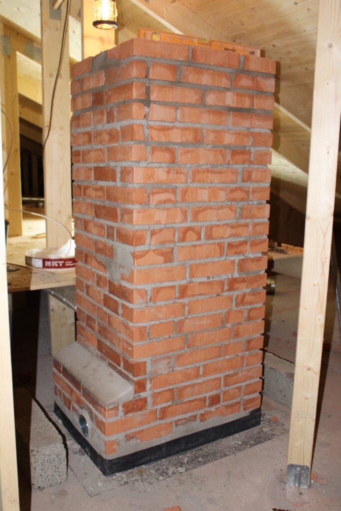 Murverk uppe på vinden med inmurad ventilationskanal för vidare dragning till aktivt ventilationssystem med fläkt